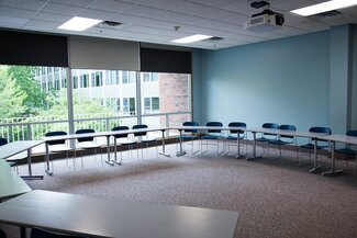 Carr Meeting Room 111A with tables, chairs and a projector